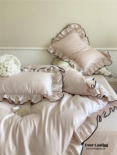 a bed with pink sheets and pillows on it