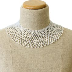 Vintage Pearl Seed Bead Woven Collar — Lace Like Bib NecklaceThe neck opening is about 14 inches (35.56 cm).It is a 2 1/2-inch wide collar that is impressive yet light and airy.A single pearl button clasp can be worn on the front or back.This necklace is woven by hand and dates from the 1950s. It is made of tiny pearlescent seed beads.This necklace is perfect for summer or any other time of the year.It is in excellent pre-owned condition with no issues to report. Classic White Handmade Beaded Necklaces, Classic Handmade White Beaded Necklaces, White Beaded Pearl Bib Necklace, White Pearl Beaded Bib Necklaces, Elegant Adjustable Bib Necklaces With Round Beads, White Pearl Beaded Bib Necklace, Elegant Adjustable Bib Necklace With Round Beads, Elegant Bib Necklace With Round Beads, Elegant White Bib Necklace With Round Beads