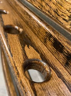 a close up of a wooden bench with holes in the wood and nails on it