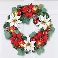 a christmas wreath with poinsettis and pine cones