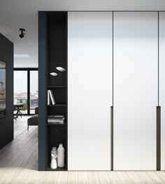 the interior of a modern apartment with white and black walls, wood flooring and sliding glass doors