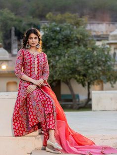 This 3-piece set includes pink floral print anarkali kurta has round-neck with thread detailing, 3/4th sleeves, flared hem, calf length teamed with printed trouser pant with single pocket & slip on waistband and an organza dupatta. Washing instructions state to hand wash. The model wearing the size small is 5'8 in height. 3 Piece Set Color-Red Suit Fabric- Cotton Dupatta Fabric-Organza Work - Floral Print detailing Neck - Round Neck with Thread Detailing Sleeves - 3/4th sleeves Length-Calf Lengt Pink Anarkali Palazzo Set With Printed Motifs, Pink Anarkali Kurta For Seasonal Transition, Pink Anarkali Kurta For Transitional Season, Designer Pink Palazzo Set With Bandhani Print, Designer Wear Pink Palazzo Set With Bandhani Print, Fitted Ankle-length Salwar Kameez With Printed Motifs, Festive Pink Kurta With Printed Motifs, Transitional Pink Kurta With Printed Motifs, Pink Printed Motifs Palazzo Set For Festivals