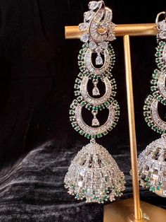 Gorgeous Handmade Statement Long Earrings in American Diamond in Sliver Color with Green Stones on all the corners and a hanging Pearl. Light Weight with back support. Item : Earring Set Color : Sliver and GreenLength of Earrings : 3.5 inches Width of Earnings - 1 inches (widest part)Circumference of the Jumka on the bottom - 4 inches Shop Polices -- Final Sale, No Return, No exchange - Please note Jewelry is delicate and Fragile, please handle with care.- There can be little variation in the co White Gold Hand Set Earrings For Party, Sterling Silver Festive Drop Chandelier Earrings, Hand Set Sterling Silver Bridal Earrings For Party, Sterling Silver Hand Set Bridal Earrings For Party, Silver Metal Danglers For Party, Traditional Silver Plug Earrings For Party, Fusion Style Hand Set Chandelier Earrings For Party, Silver Hand Set Crystal Earrings For Party, Fusion Style Silver Chandelier Earrings For Formal Events