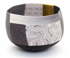 a black and white bowl with three different designs on the inside, sitting in front of a white background