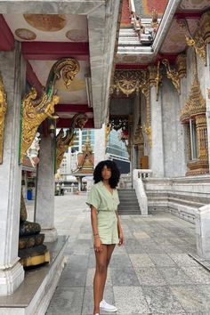 a woman standing in front of a building with gold and white decorations on the walls