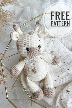 a crocheted stuffed animal sitting on top of a white blanket with stars around it