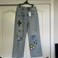 Forever 21 Non-Stretch Denim Jeans Features A Light Wash, Belt Loops, Distressing, Allover Doodle Graphics And Cactus And Floral Patches. Loose Fit Relaxed Leg 90's Fit New Size 28 Trendy Cotton Jeans With Graphic Print, Trendy Graphic Print Cotton Jeans, Medium Wash Jeans With Graphic Print For Spring, Spring Jeans In Medium Wash With Graphic Print, Medium Wash Graphic Print Bottoms For Spring, Spring Graphic Print Medium Wash Bottoms, Trendy Spring Jeans With Graphic Print, Spring Graphic Print Bottoms In Medium Wash, Trendy Graphic Print Denim Blue Bottoms