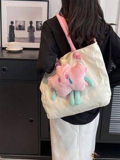 a woman carrying a pink and blue stuffed animal bag