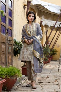 The set consists of straight cut handwork printed kurta with gota detailing, 3/4th sleeves, round neck, knee length teamed with printed trouser and a dupatta with border. Suit Fabric-Georgette Dupatta Fabric-Organza Kurta length - 40 in Pants length - 38 in Model is wearing size small. She is 5.8” tall. Washing Care-Dry Clean Organza Kurta, Grey Suit, Suit Fabric, Gray Suit, Suit Set, Straight Pants, Straight Cut, Kimono Top, Knee Length