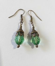 Emerald green Victorian bronze earrings Boho earrings Bronze earrings Bohemian earrings Vintage emerald green teardrop flower earrings gift boho earrings Edwardian earrings Gothic earrings Beautiful bronze Victorian style earrings with emerald green teardrop faceted glass beads. Antique style bronze tone Emerald green filigree earrings . Boho earrings. Bohemian earrings . Romantic style earrings. Baroque style earrings . Beautiful emerald-green earrings.  Perfect Gift for Her ! FREE SHIPPING  The Chain measures approximately 46 cm ( 18.20 inches). Material: bronze tone pendant, green teardrop faceted glass beads, bronze tone chain , bronze toned ornaments beads.  Length of necklace :  18.20 ( 46cm) Length of earrings with hooks - 1.7 (4.5 cm) If you have any question, please contact me ! T Bohemian Green Pierced Teardrop Earrings, Bohemian Green Teardrop Pierced Earrings, Green Crystal Metal Earrings, Green Metal Teardrop Earrings Elegant Style, Elegant Green Metal Teardrop Earrings, Green Brass Drop Earrings, Elegant Green Teardrop Metal Earrings, Vintage Emerald Drop Earrings, Handmade Green Crystal Metal Earrings