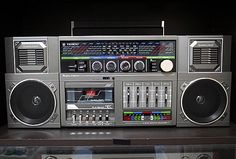 an old fashioned radio with speakers and other electronic equipment on display in a glass case