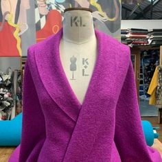 a mannequin wearing a purple coat in a store