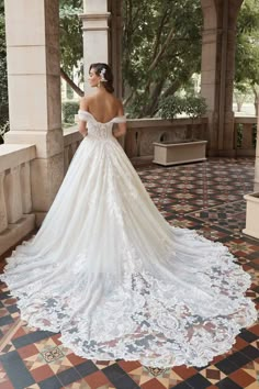 a woman in a wedding dress is standing on the porch with her back to the camera