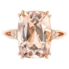 an 18k rose gold ring set with a cushion cut morganite and diamond accents