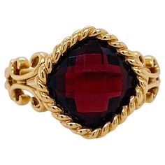 Adorn a magnificent finger with this gorgeous 3.50 carat garnet ring! Garnet is January's birthstone and this gorgeous ring will be a fabulous way to celebrate your January loved one. The rich color of the garnet is accented by the checkerboard facets and warm gold setting. Stylized fleur-de-lis designs accent the band of the ring below the bold twisted cable bezel around the delightful cushion garnet. This ring is marked down from the original price of $1,350. Wear a piece that speaks to your style! Classy and bold, but graceful. This ring is a size 7 and it can be sized upon request. Please note that if the ring is resized for you, the item becomes a custom final sale and cannot be returned. Thank you for understanding. The details for this beautiful ring are listed below: Metal Quality: Luxury Garnet Ring With Center Stone, Luxury Garnet Rings With Accent Stones, Luxury Garnet Jewelry With Center Stone, Luxury Garnet Gemstone Rings, Elegant Garnet Birthstone Ring With Center Stone, Formal Garnet Birthstone Ring In Fine Jewelry Style, Formal Garnet Birthstone Ring Fine Jewelry, Formal Garnet Birthstone Ring, Formal Garnet Rings With Gemstone Accents