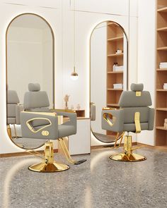 two gray chairs with gold accents in front of a mirror and shelving unit behind them