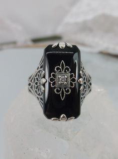 Black Glass/Stone & inset CZ, Moissanite, or Diamond Ring Grace Design#233 Custom Made I now offer this lovely Antique Art Deco/Edwardian design ring in sterling silver. This gorgeous ring is set with a stunning floral filigree embellished black glass/resin with a centered set 1mm white round cut gemstone (Choose White CZ, Lab White Moissanite, or Natural/Genuine White Diamond). The Black glass is 18mm Long by 19mm Wide. The ring sits 19mm North South on the finger and 10mm East West on the Classic Black Jewelry With Accent Stones, Black Filigree Ring With Intricate Design For Formal Occasions, Classic Black Filigree Ring For Formal Occasions, Black Filigree Ring For Formal Occasions, Antique Black Jewelry For Wedding, Elegant Black Filigree Ring For Anniversary, Elegant Black Jewelry With Accent Stones, Black Jewelry With Intricate Design For Anniversary, Antique Black Wedding Jewelry