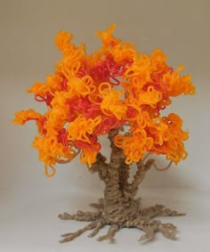 an orange and red tree is shown on a white surface