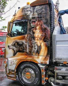 a semi truck painted with an image of a woman and wolf on it's side