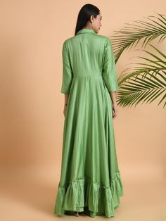 A shawl collared cotton silk maxi dress with flared and flounced bottom, side pockets, and long sleeves Garment measurements (in Inches): Small: Bust - 39", Waist - 29" Medium: Bust - 42", Waist - 32" Large: Bust - 45", Waist - 35" Length: 55-56", Sleeve length: 17" Fabric: Cotton Silk Color: Green Fit: Model height is 5'7" Model is wearing a size S Loose and comfortable fit. Instructions: Hand wash separately in cold water Note: Available in other colors Pants not included with the product Pant Anarkali Dresses With Ruffles, Festive Ruffled Maxi Dress, Festive Maxi Dress With Ruffles, Summer Anarkali Dress With Ruffles, Fitted Anarkali Dress With Ruffles, Green Silk Long Sleeve Maxi Dress, Spring Long Sleeve Gown With Ruffles, Spring Silk Maxi Length Kurta, Silk Maxi Dress With Ruffle Hem