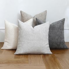 four pillows sitting on top of a wooden floor