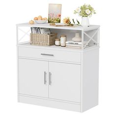 a white cabinet with some flowers and books on top of it next to a basket