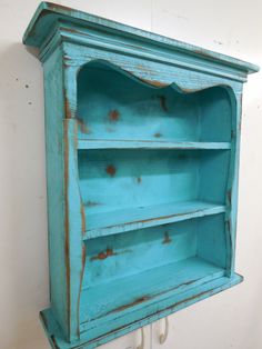 an old blue bookcase with rusted paint on it