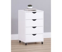 a white cabinet with four drawers and a plant on top