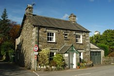 an old stone building sitting on the side of a road