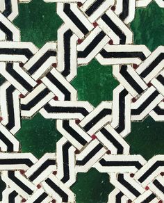 a close up view of a green and white tile pattern with black lines on it