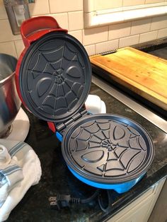 a spider web waffle maker sitting on top of a counter next to a pot