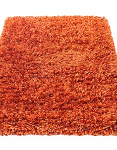 an orange shaggy rug on a white background