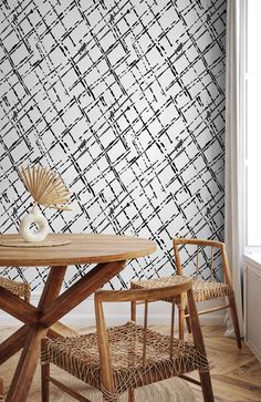 a table and chairs in front of a wallpapered room with an abstract design