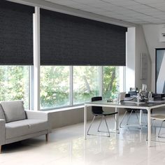 a living room filled with furniture and windows covered in roman blind shades on top of them