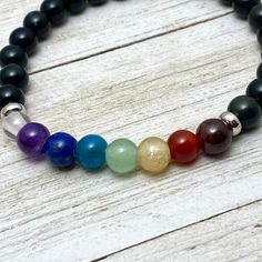 6 mm chakra gemstone bracelet Inspires balance of your 7 Chakras All natural gemstone beads: Crown (Clear or white), Third Eye (Purple ), Throat (Blue), Heart (Green), Solar Plex (Yellow), Sacral (Red-Orange), Root (Black-Silver) actual gemstones could vary based on availability, variations in color or size is a natural occurrence. Made with natural Obsidian base beads and strong elastic for years of easy wear. Message any special requests and options upon checkout Accent beads are solid stainle Spiritual Rainbow Gemstone Beaded Bracelets, Rainbow Gemstone Beads Bracelets For Healing, Rainbow Gemstone Beads Bracelet For Healing, Rainbow Gemstone Beads Healing Bracelet, Rainbow Crystal Bracelet With Natural Stones For Healing, Healing Rainbow Natural Stone Bracelets, Rainbow Bracelets With Round Natural Stones, Rainbow Crystal Bracelet With Natural Stone Round Beads, Gemstone Bracelet With Round Beads For Meditation