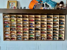 a wooden shelf filled with lots of toy cars