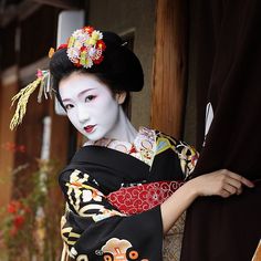 a geisha woman with white makeup and black hair