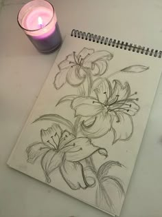 a pencil drawing of flowers next to a lit candle on a white paper with black ink