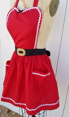 a mannequin wearing a red dress with white trims and a black belt