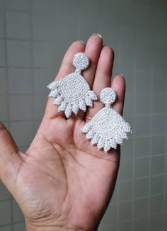 "Handmade white beaded flower bridal earrings. The stunning pair of floral bridal earrings are hand-embroidered of white tiny seed beads. These are light weight and ideal option for the Brides. Earrings measure approx. 2.10\" long and 1.75\" wide. At Carnation jewellery, each piece is handmade, handcrafted and shipped from  India, there may be a slight imperfection due to the nature of work but we try our best to make them look perfect. * SHIPPING - Please refer to the \"announcement\" at the to White Pearl Drop Dangle Bridal Earrings, White Pearl Drop Bridal Dangle Earrings, Delicate White Crystal Earrings For Party, White Beaded Dangle Crystal Earrings, Handmade White Earrings For Wedding, Handmade White Dangle Crystal Earrings, White Drop Bridal Earrings For Parties, Beaded Dangle Flower Earrings For Wedding, Beaded Crystal Earrings For Wedding