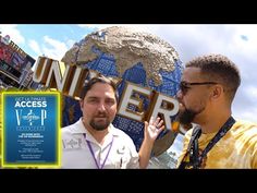 two men standing next to each other in front of a sign that says universal studios