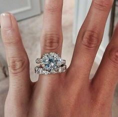 a woman's hand with an engagement ring on it