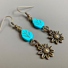 "Sunflower Earrings - Brass plated Sunflowers dangle from Turquoise Czech Glass Leaf Beads and Twisted Antiqued Brass plated Rings. Antiqued Brass Earwires Earrings measure j2.25\" from top of earwire to bottom of flowers." Vintage Flower Charm Dangle Earrings, Nature-inspired Hypoallergenic Flower Drop Earrings, Turquoise Dangle Earrings With Flower Charm, Nature-inspired Drop Flower Earrings For Pierced Ears, Adjustable Flower-shaped Nature-inspired Earrings, Vintage Dangle Earrings With Flower Charm, Nature-inspired Adjustable Flower Earrings, Nature-inspired Dangle Flower Earrings, Nature-inspired Hypoallergenic Flower Dangle Earrings