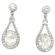 A beautifully designed pair of platinum and diamond drop earrings. The earrings are set with 2.89 carat oval rose cut diamonds. The mandolin style frame setting has .23 carats pear shaped diamonds, and .90 carats round diamonds. The combination of the 2 different diamond cuts catch the light just perfectly. The post back earrings measure 1.25" x .50". Stamped PLAT Luxury Vintage Single Cut Diamond Earrings, Luxury Fine Jewelry Chandelier Earrings With Prong Setting, Luxury Oval Bridal Earrings For Formal Occasions, Luxury Rose Cut Drop Diamond Earrings, Formal Pear-shaped Diamond Earrings With Single Cut Diamonds, Luxury Oval Bridal Earrings With Prong Setting, Exquisite Oval Diamond Earrings With Accents, Luxury Oval Diamond Earrings For Formal Events, Luxury Oval Diamond Earrings For Formal Occasions