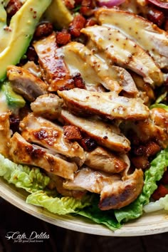 a salad with chicken, lettuce and tomatoes