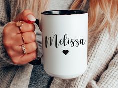 a woman holding a coffee mug with the word melissa written on it in black