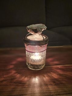 a lit candle sitting on top of a wooden table