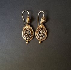 I purchased these beautiful Memento Mori, Mourning Earrings years ago, and have never worn them.  When I purchased them, I was told that the raised center, which is able to be removed by a jeweler, would contained a lock of a loved one's hair.  I have never investigated this.  They are gold with a seed pearl in the center.  There's a draped ribbon of silver below.  A gold bead hangs from the bottom. The background and trim is black enameled.    I don't feel comfortable wearing dangling earrings, so I reluctantly decided to sell them.  I hope they go to someone who will appreciate the design and the workmanship. Victorian Engraved Earrings For Formal Occasions, Formal Engraved Drop Earrings, Antique Evening Earrings For Pierced Ears, Victorian Style Hallmarked Earrings For Formal Occasions, Victorian Oval Pierced Earrings, Vintage Gold Diamond Pierced Earrings, Antique Yellow Gold Earrings For Formal Events, Antique Yellow Gold Earrings For Formal Occasions, Formal Victorian Hallmarked Earrings