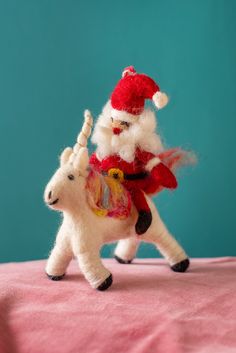 a santa clause riding on the back of a white horse with a red hat and tail