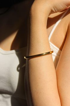 PRODUCT DESCRIPTION Golden simplicity. This piece is a minimalist statement piece for any look. The Ava Plain bangle celebrates the beauty of expert craftsmanship. Formed from polished titanium steel and coated with gleaming 18-karat gold for an opulent finish, this bangle adds a suave touch to your wrist – whether worn alone or stacked alongside your favourite timepiece. A must-have addition to your jewellery addition. Signature Gold Bangle Water Resistant 18k Gold-plated on titanium steel One Modern Shiny Yellow Gold Cuff Bracelet, Modern Yellow Gold Cuff Bracelet With Shiny Finish, Everyday Tarnish Resistant Cuff Bangle, Modern Polished Bangle, Modern Shiny Cuff Bangle Bracelet, Modern Bangle With Bracelet Strap For Formal Occasions, Everyday Gold Timeless Cuff Bracelet, Gold Cuff Bracelet With Polished Finish For Everyday Luxury, Timeless Gold Cuff Bracelet For Everyday Wear